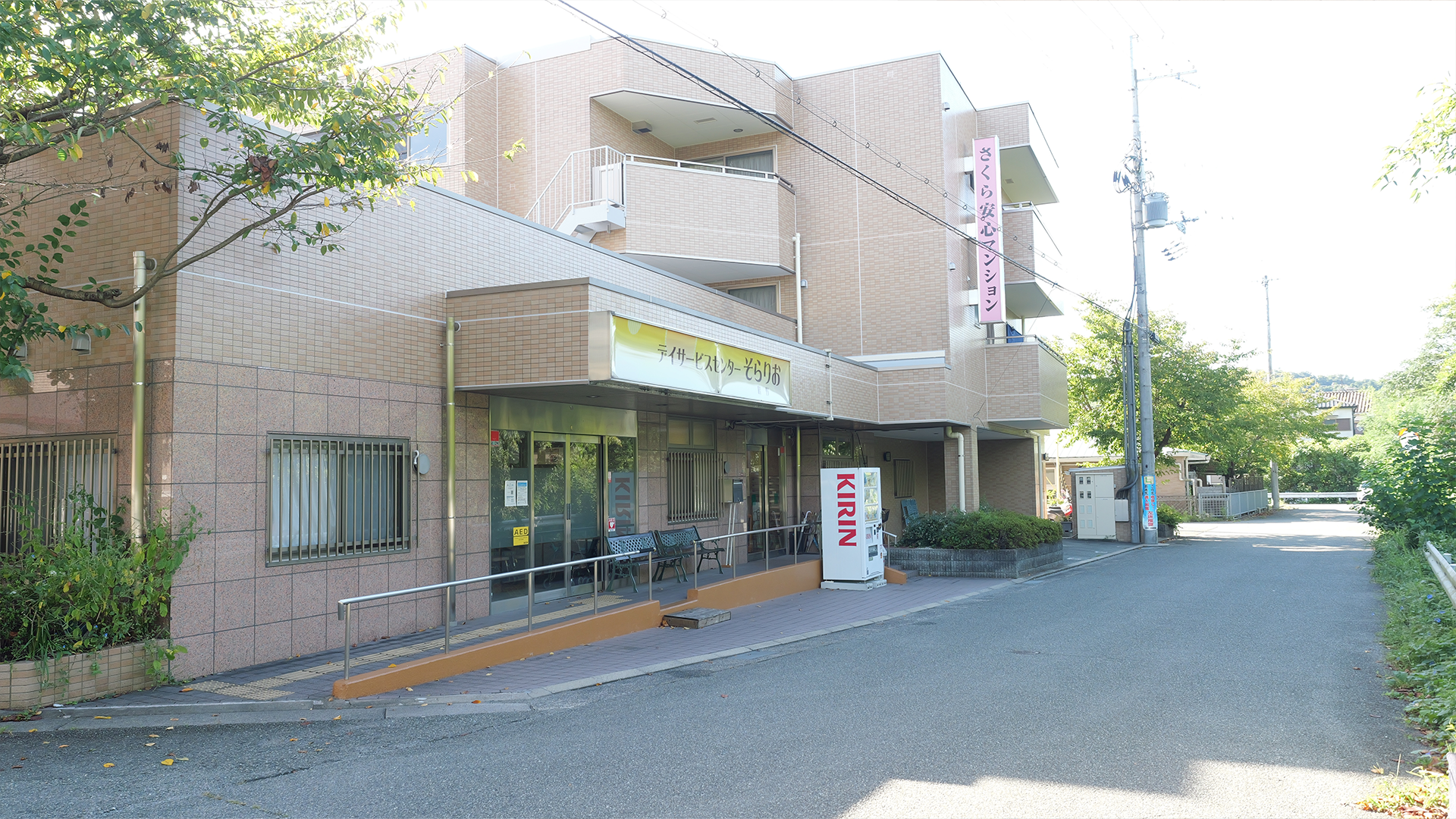 そらりお畦野デイサービス入口外観（ピンクの看板・スロープ・自販機）